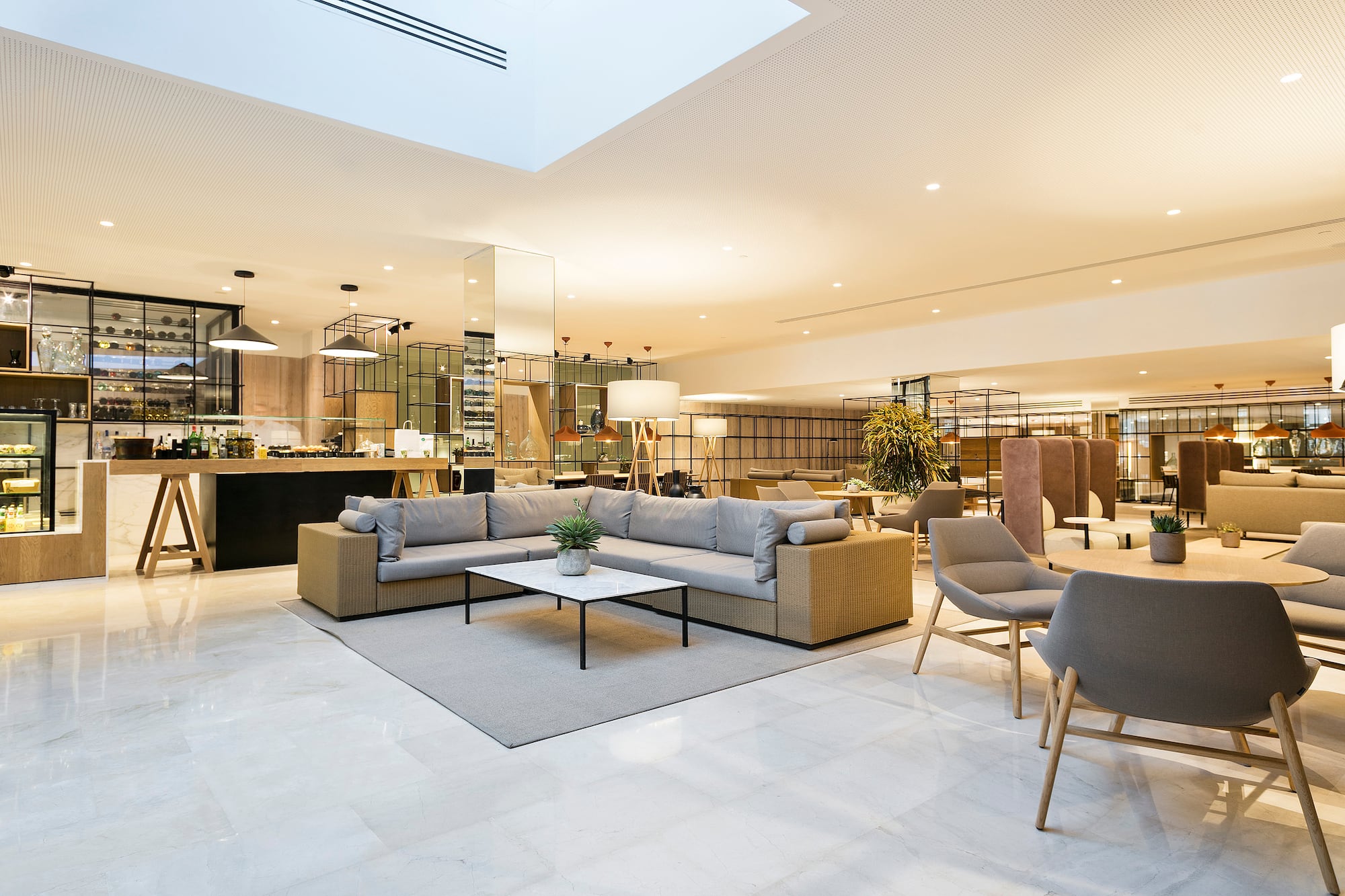 Modern hotel lounge with cafe bar, comfortable seating, and bright interior.
