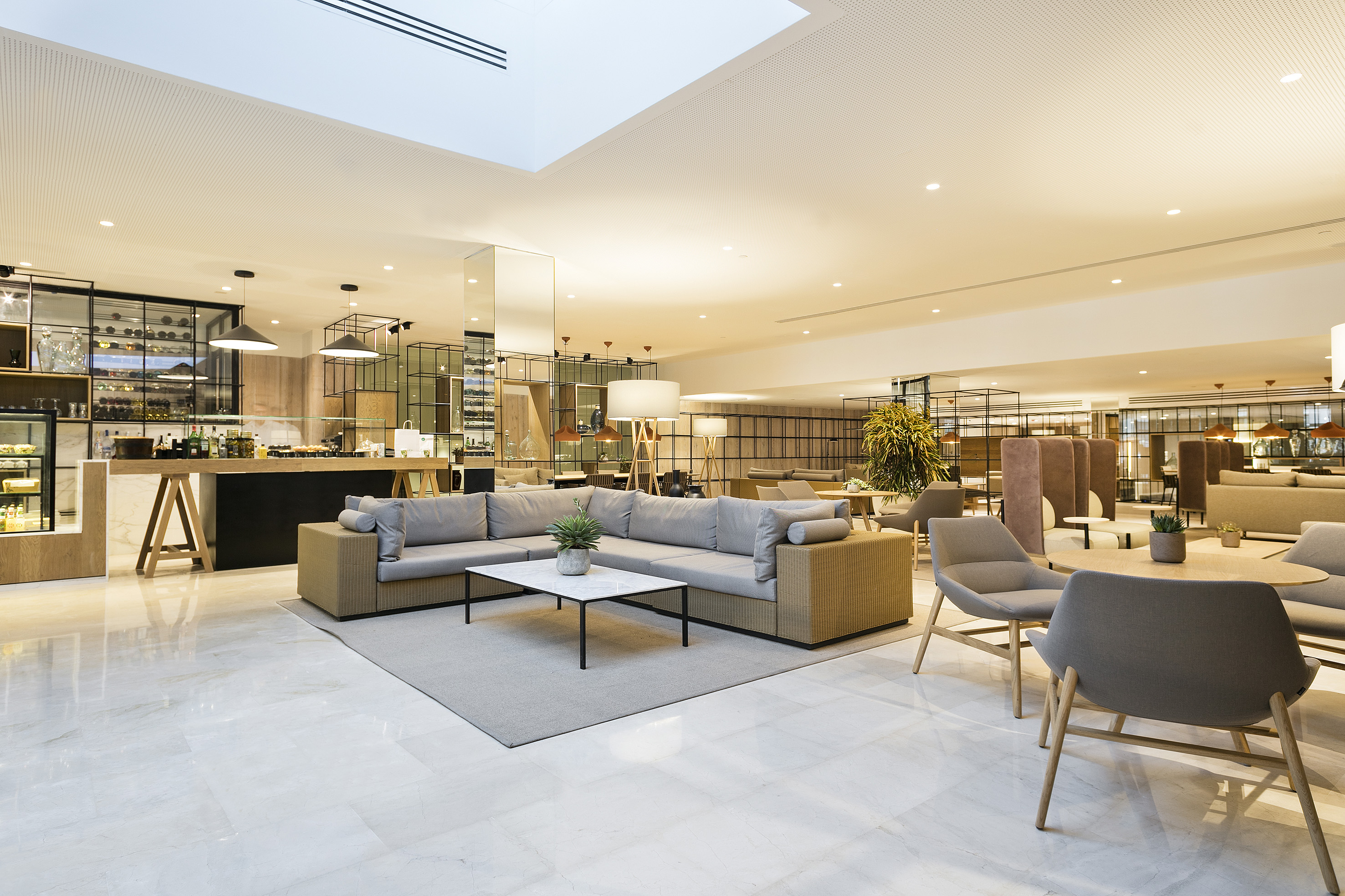 Modern hotel lounge with cafe bar, comfortable seating, and bright interior.