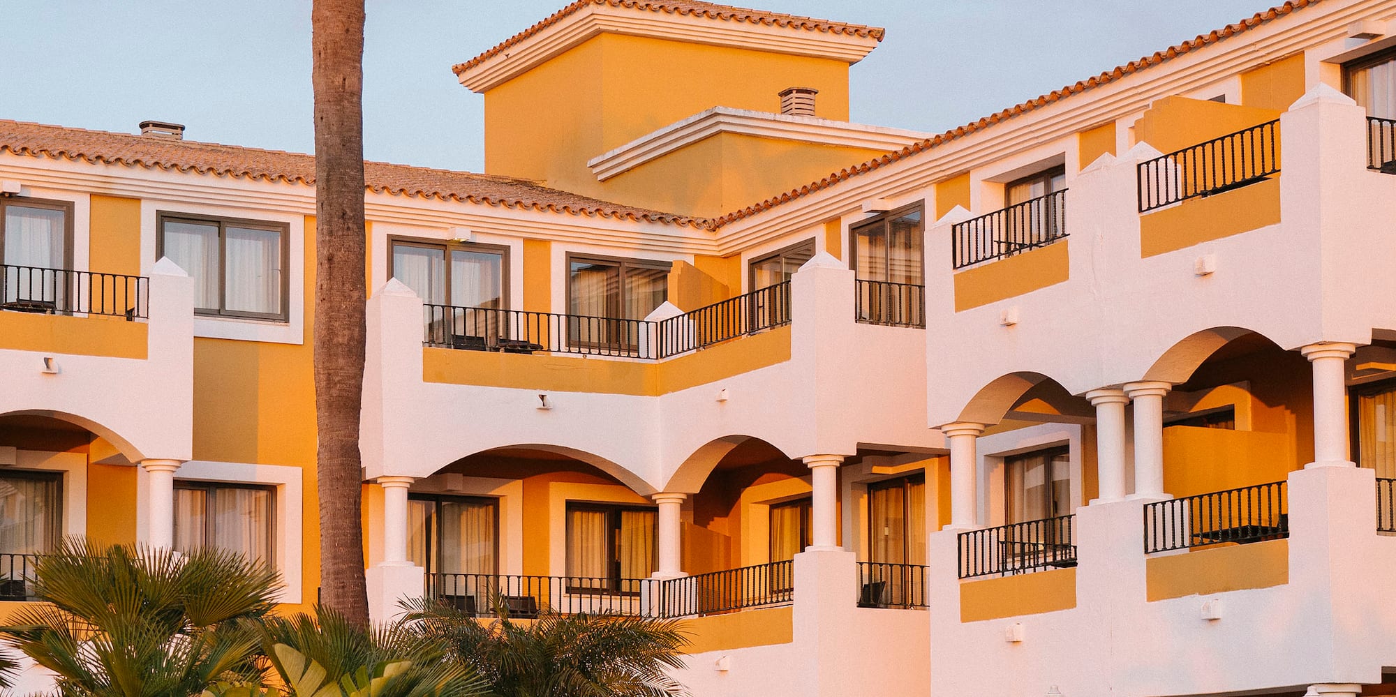 a building with palm trees and bushes