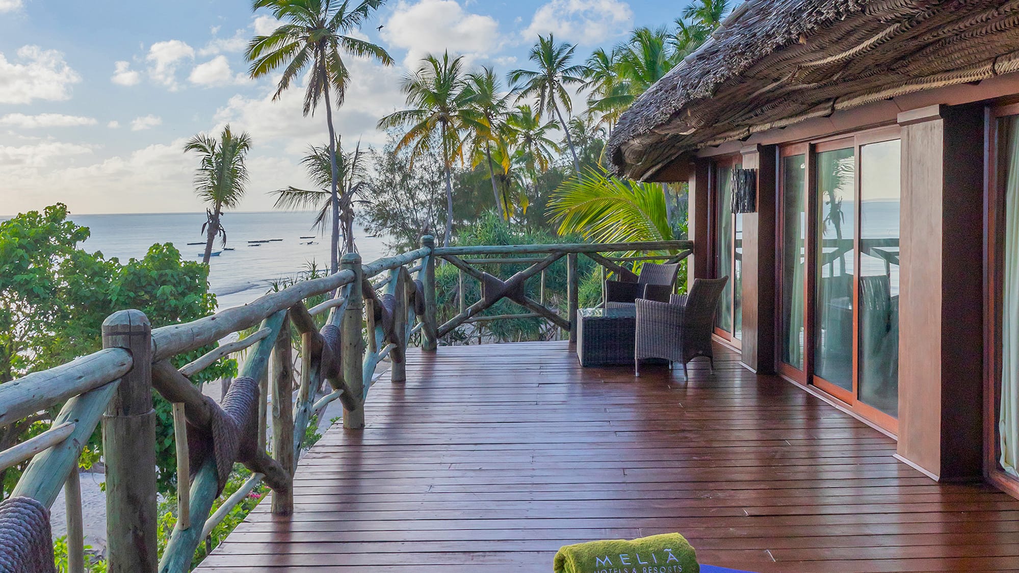 Oceanfront Melia resort balcony, wooden deck, tropical palm trees.