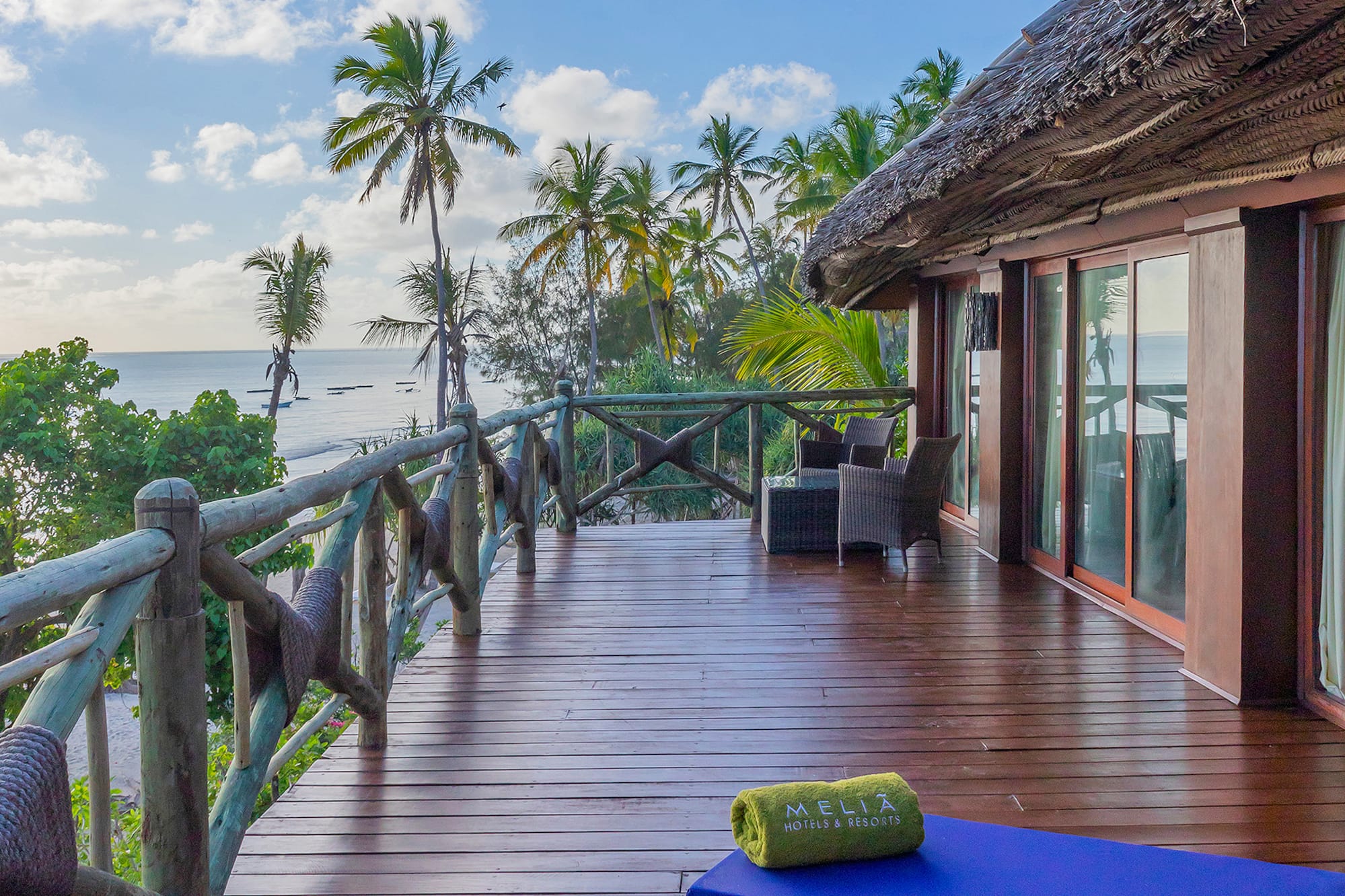 Oceanfront Melia resort balcony, wooden deck, tropical palm trees.