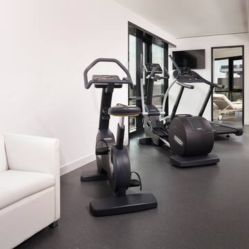 a room with exercise bikes and a white couch