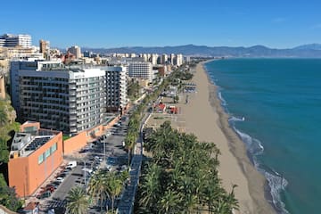a beach with buildings and palm trees