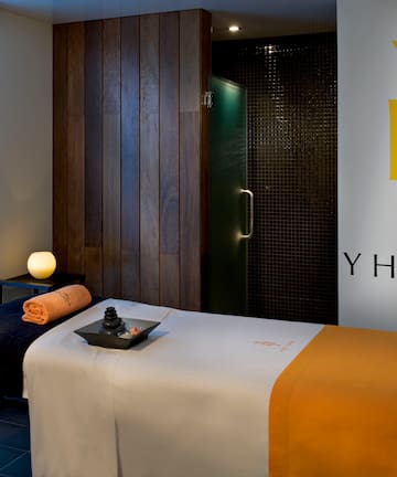 a massage room with a bed and a candle