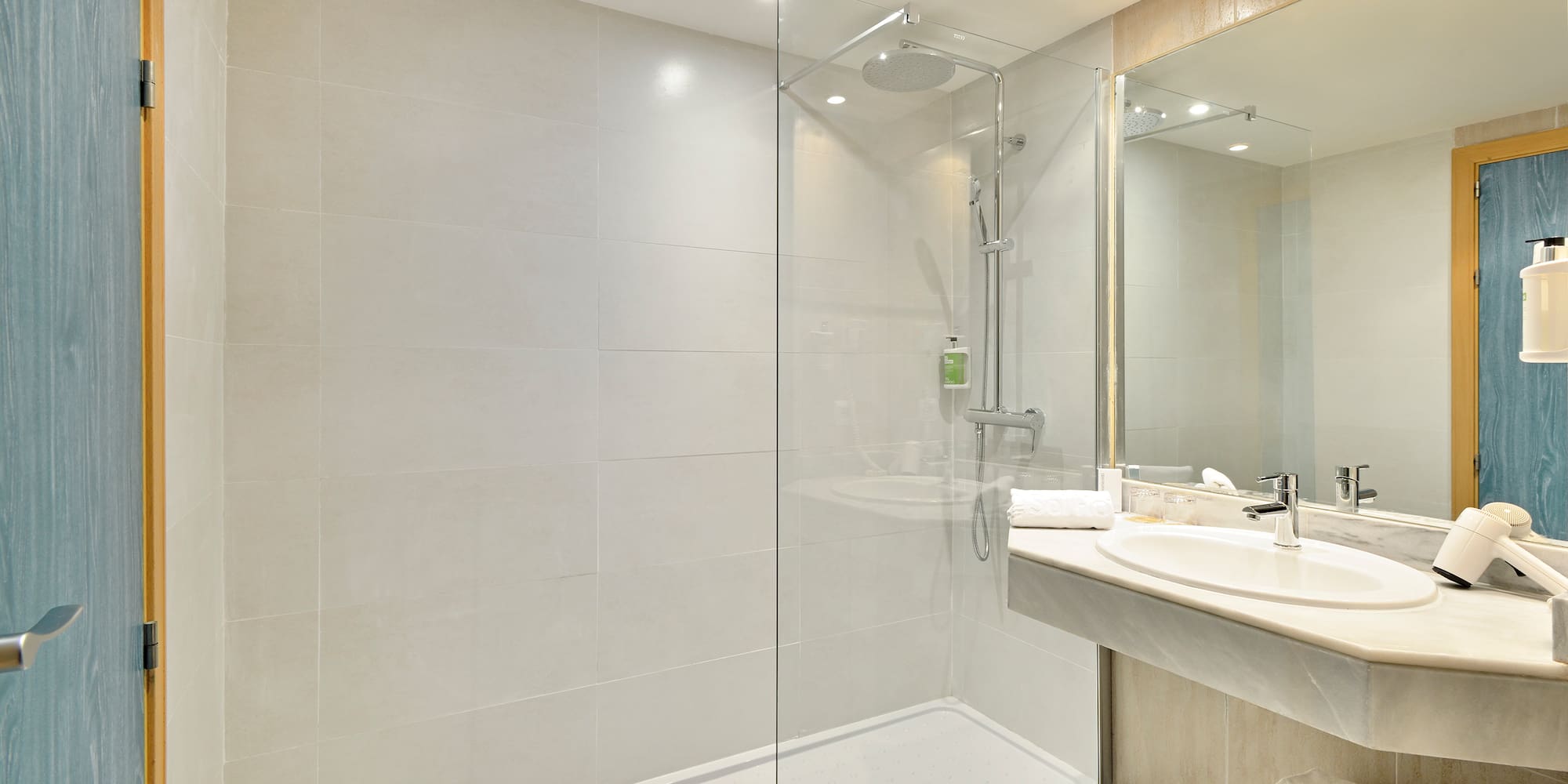 a bathroom with a glass shower and sink