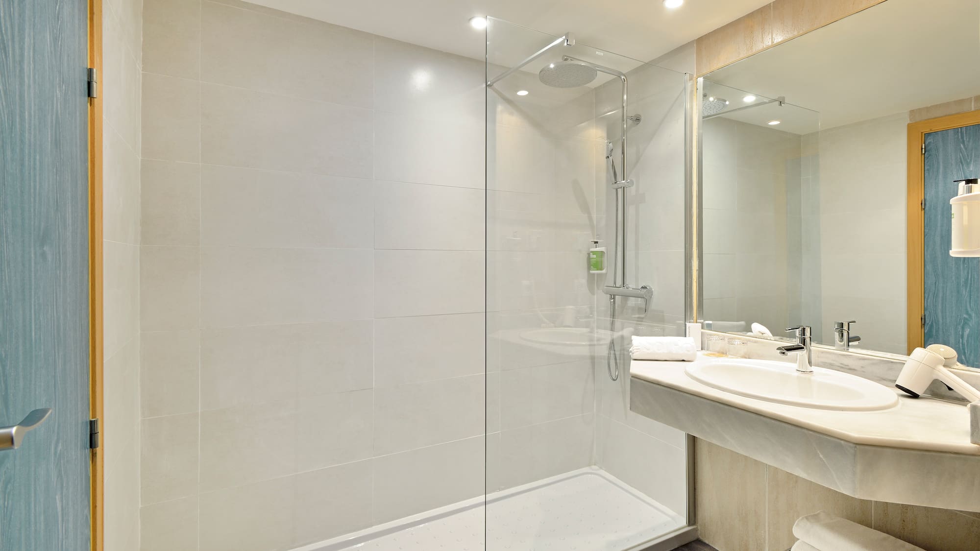 a bathroom with a glass shower and sink