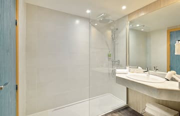a bathroom with a glass shower and sink