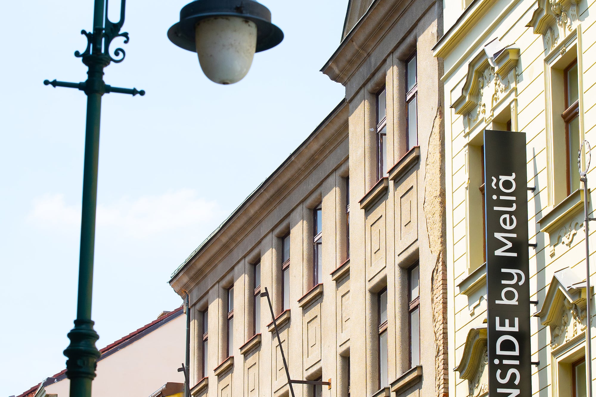 Ornate streetlamp and "INNSIDE by Meliã" hotel sign on historic city building.