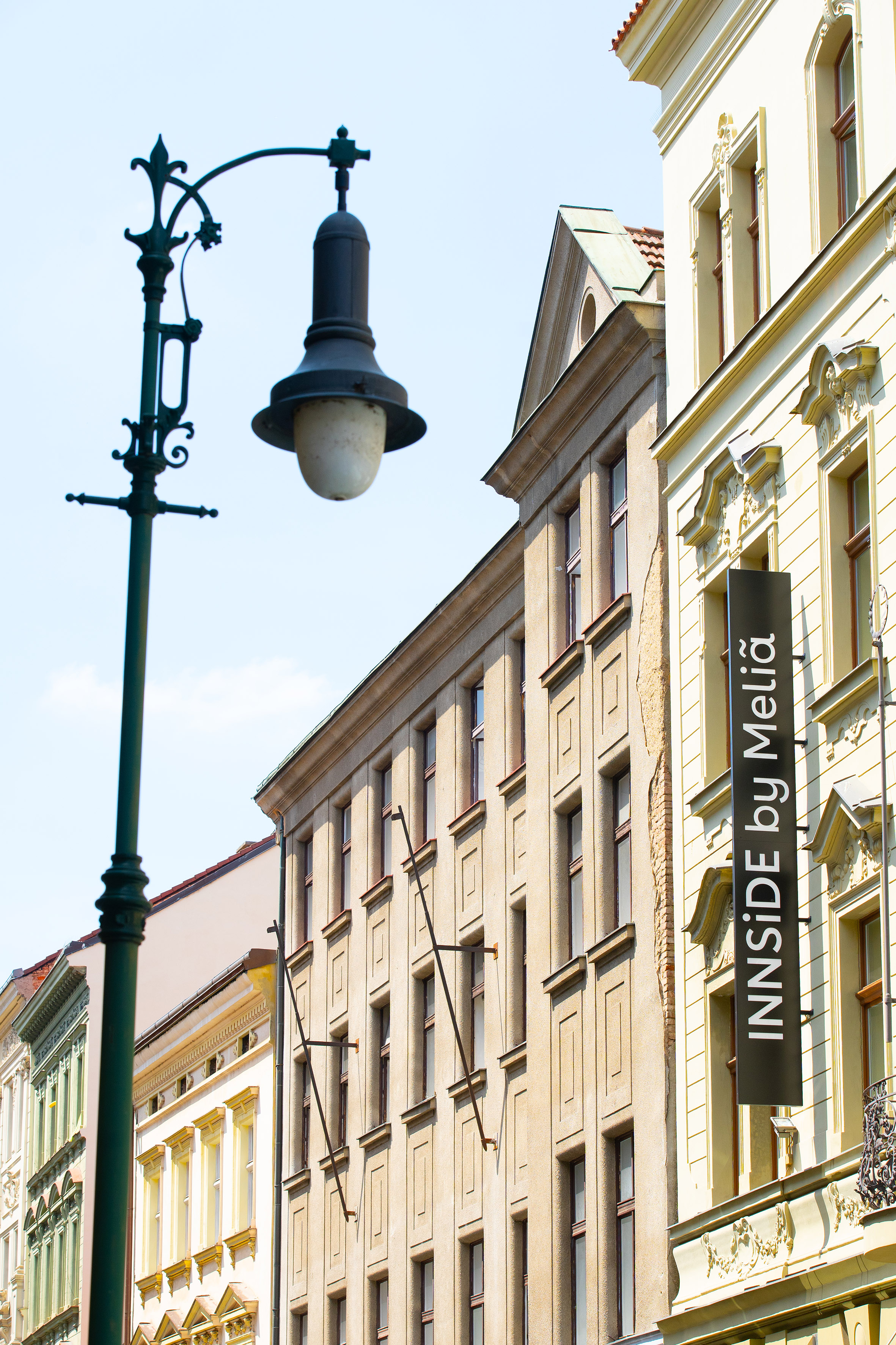 Ornate streetlamp and "INNSIDE by Meliã" hotel sign on historic city building.