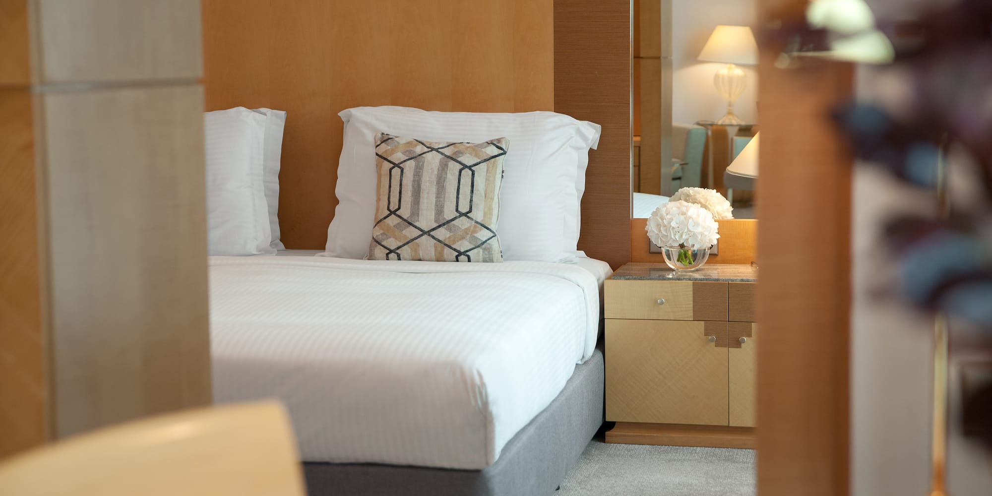 a bed with pillows and a nightstand in a room