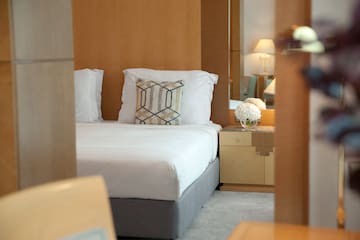 a bed with pillows and a nightstand in a room