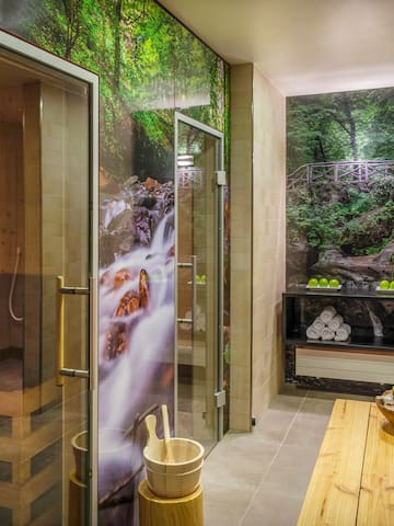a room with a glass shower and a wooden bench