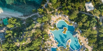 an aerial view of a resort with a pool and trees