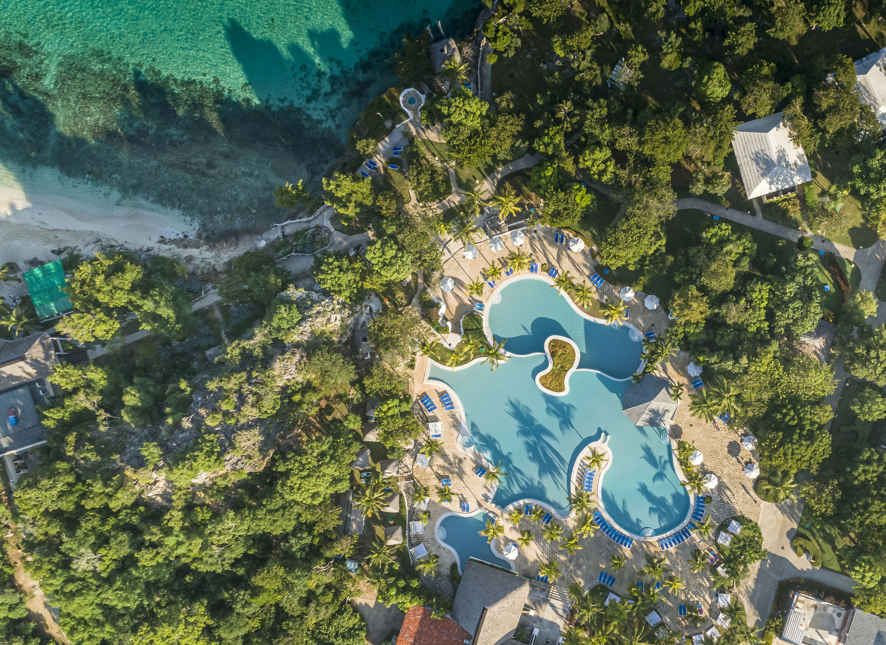 an aerial view of a resort with a pool and trees