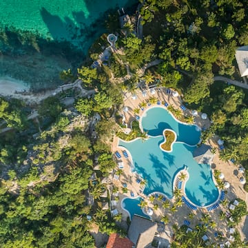 an aerial view of a resort with a pool and trees