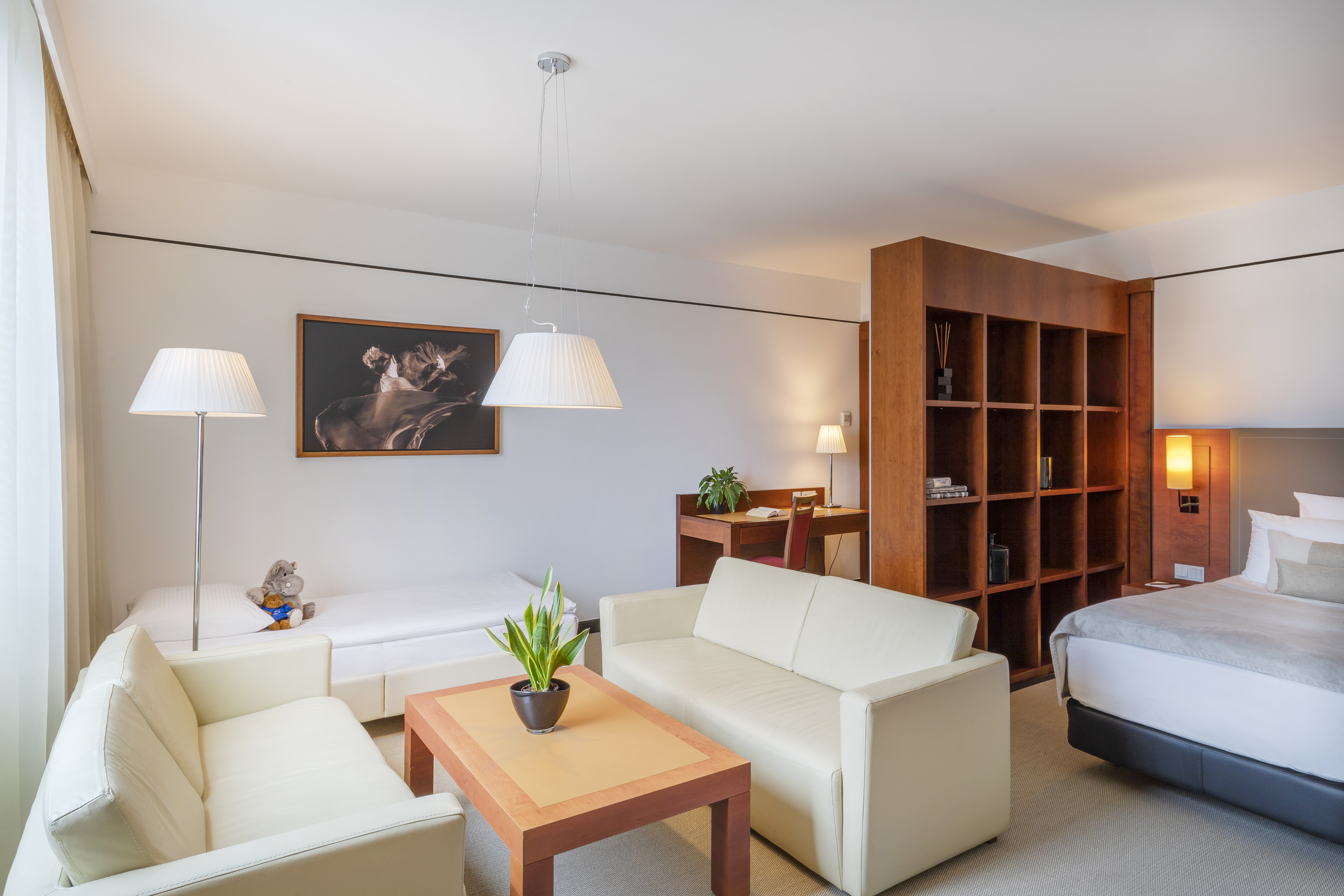 Modern hotel suite featuring living area, work desk, and separate bedroom.