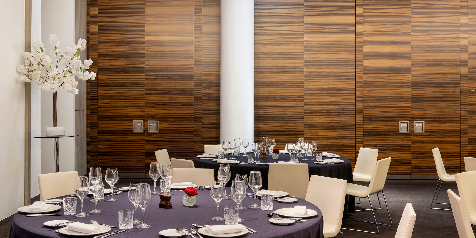 a round table set up in a room with a white column
