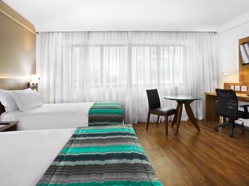 a room with two beds and a desk