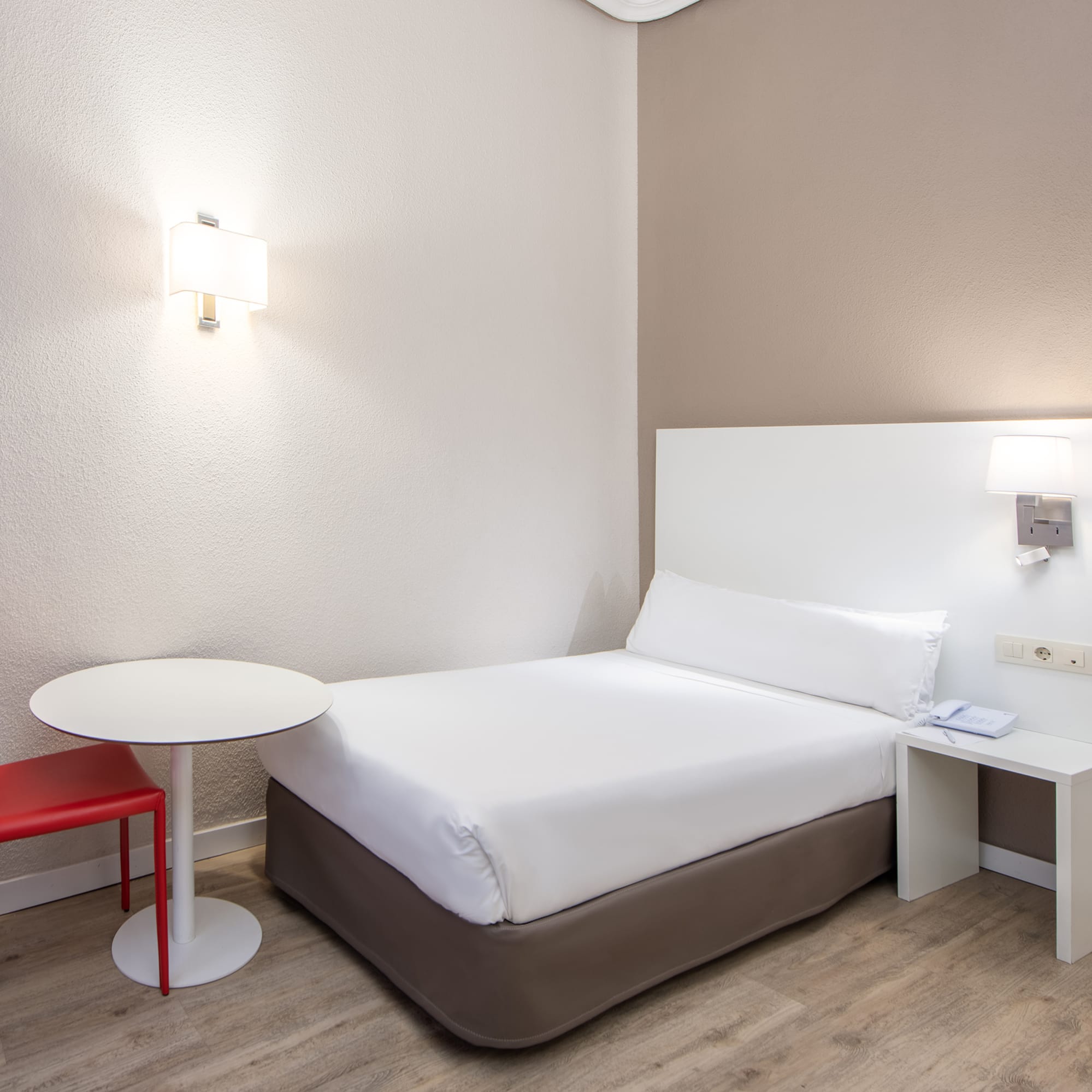 a bed with a table and lamp