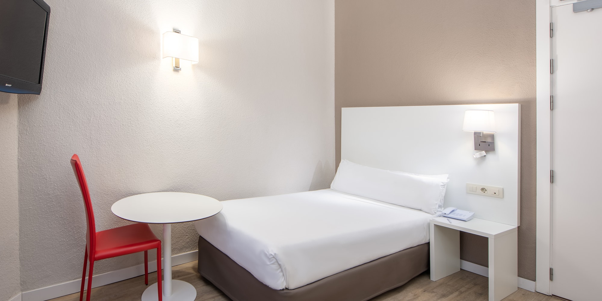 a bed with a table and lamp
