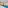 Modern indoor swimming pool with blue water, lounge chairs, and white walls.