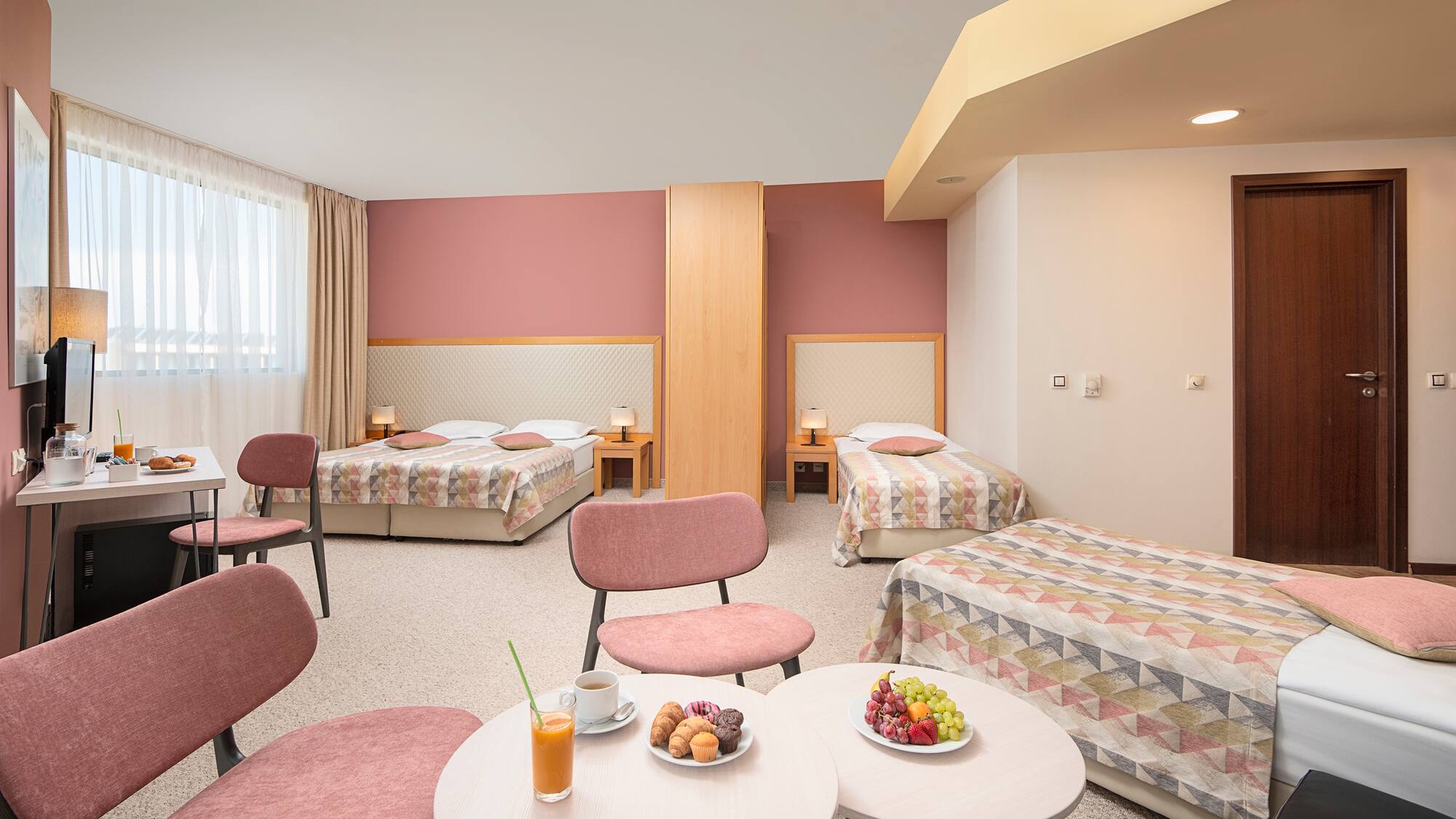 a room with beds and tables and chairs