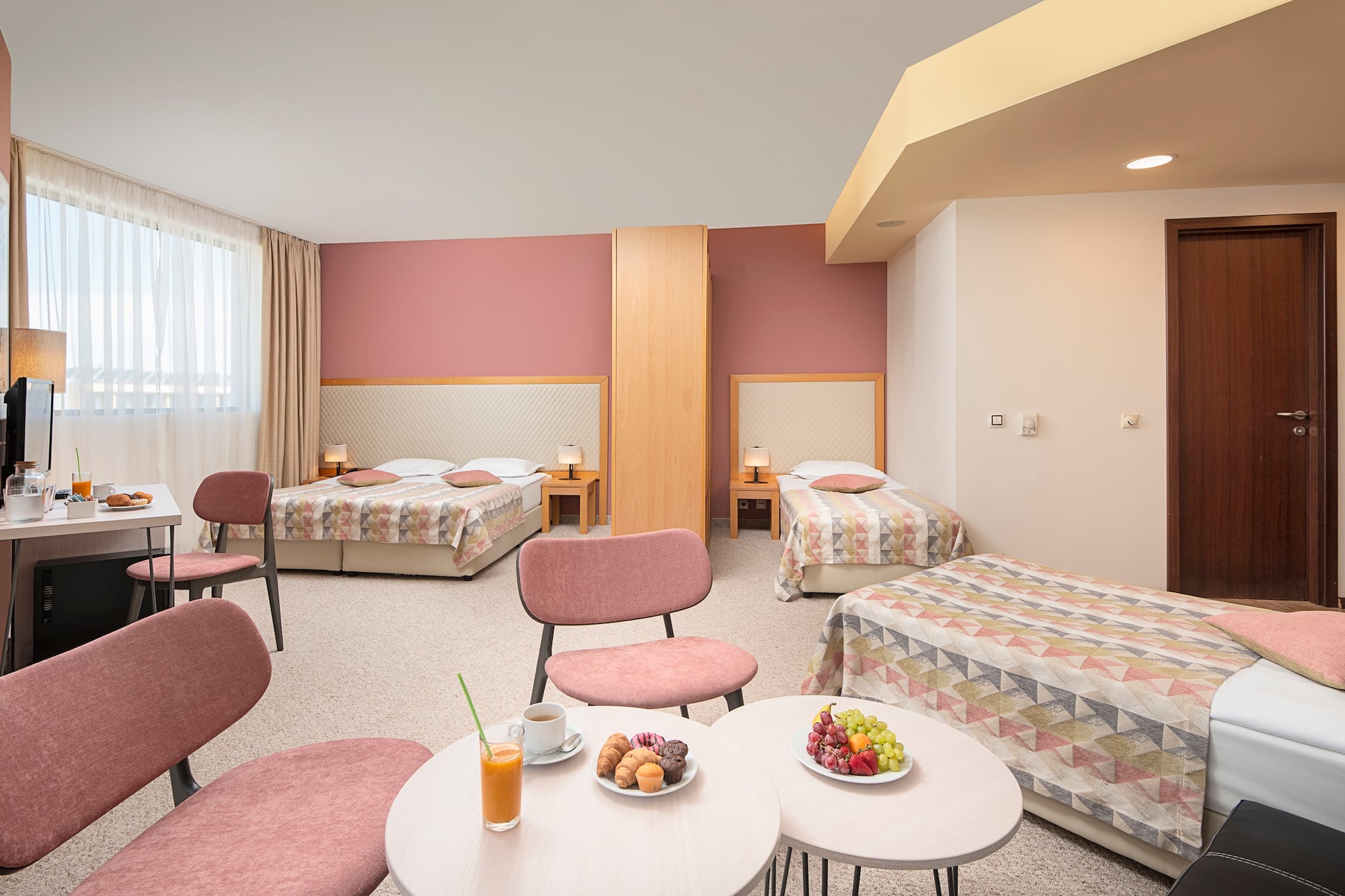 a room with beds and tables and chairs