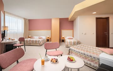 a room with beds and tables and chairs