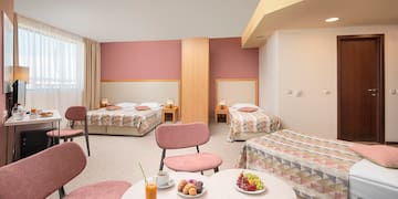 a room with beds and tables and chairs