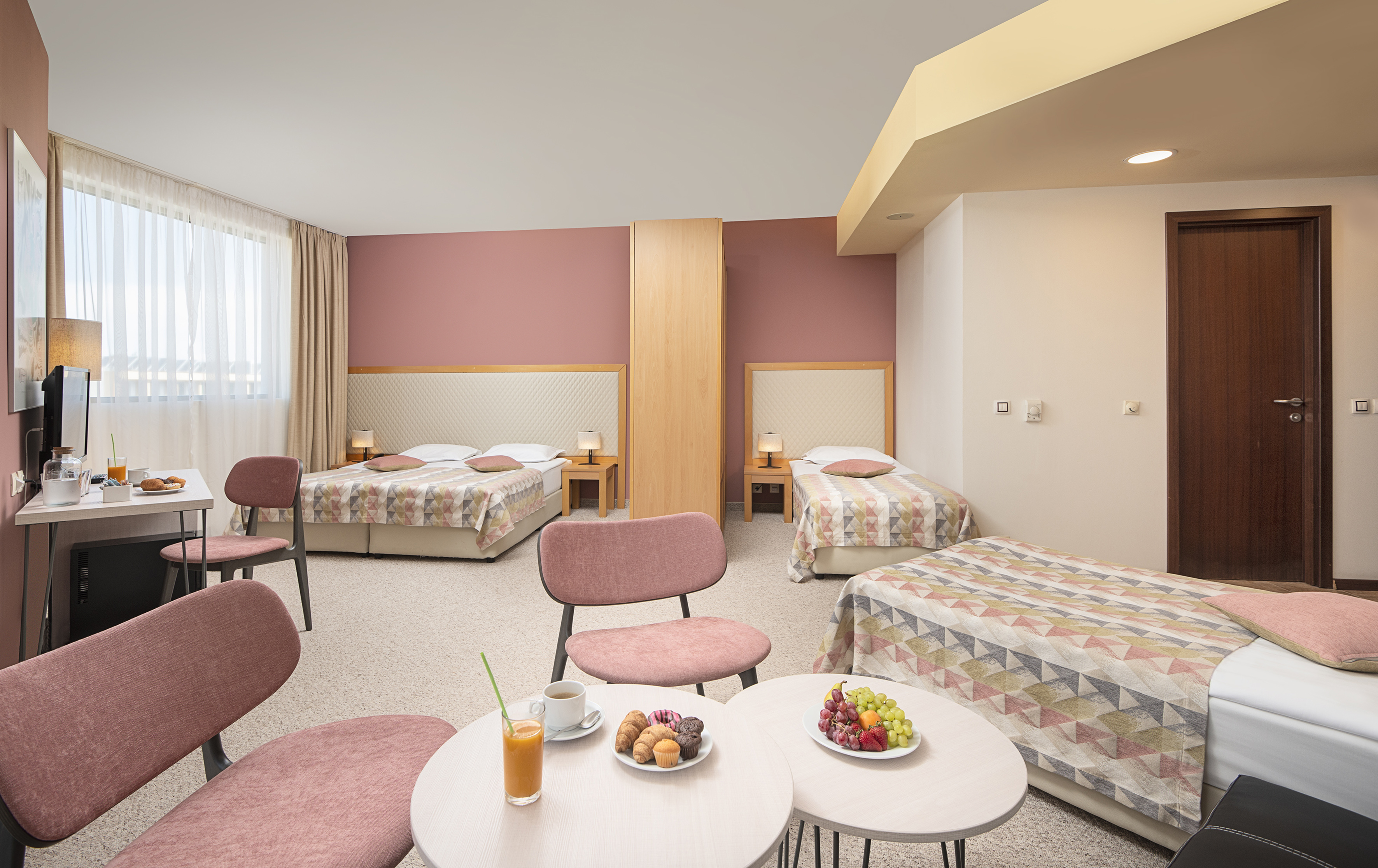 a room with beds and tables and chairs