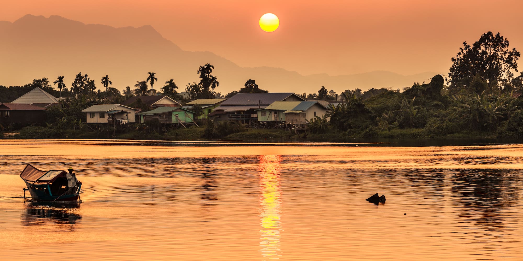 a body of water with houses and trees in the background