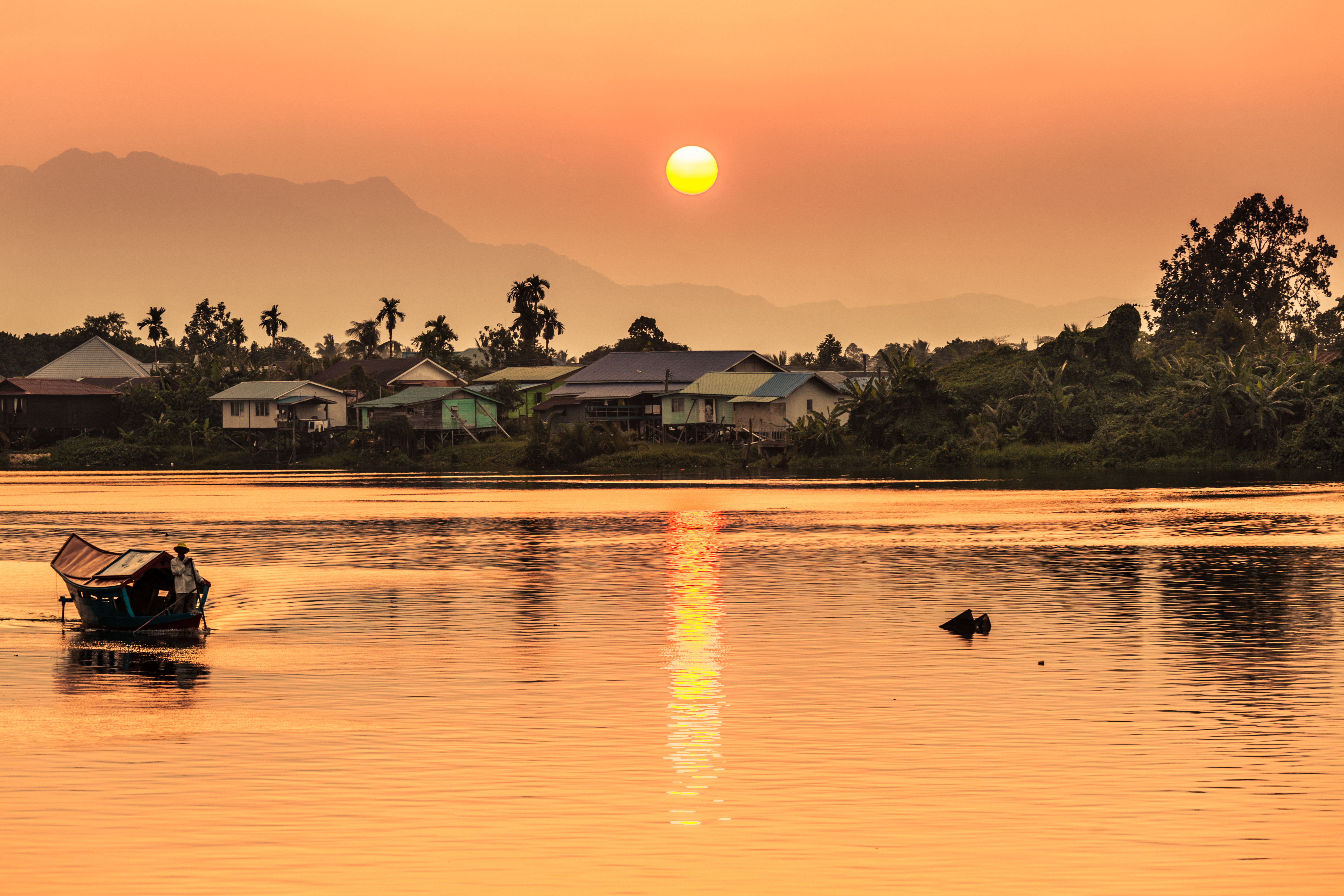 a body of water with houses and trees in the background