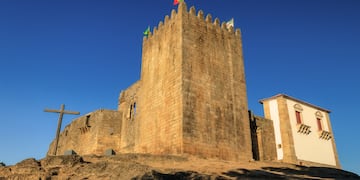 a stone castle with flags on top