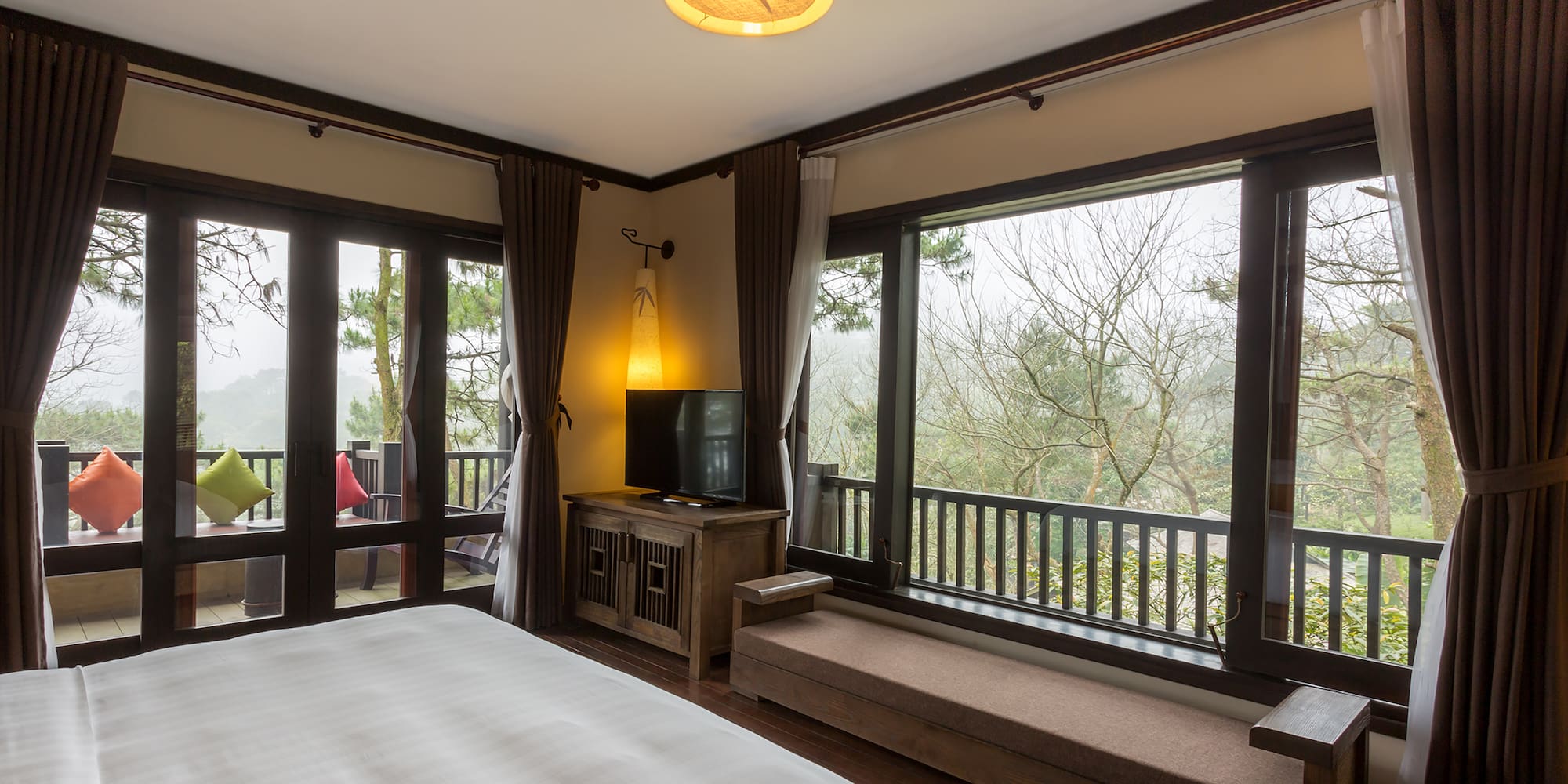 a bedroom with a bed and a bench and a window