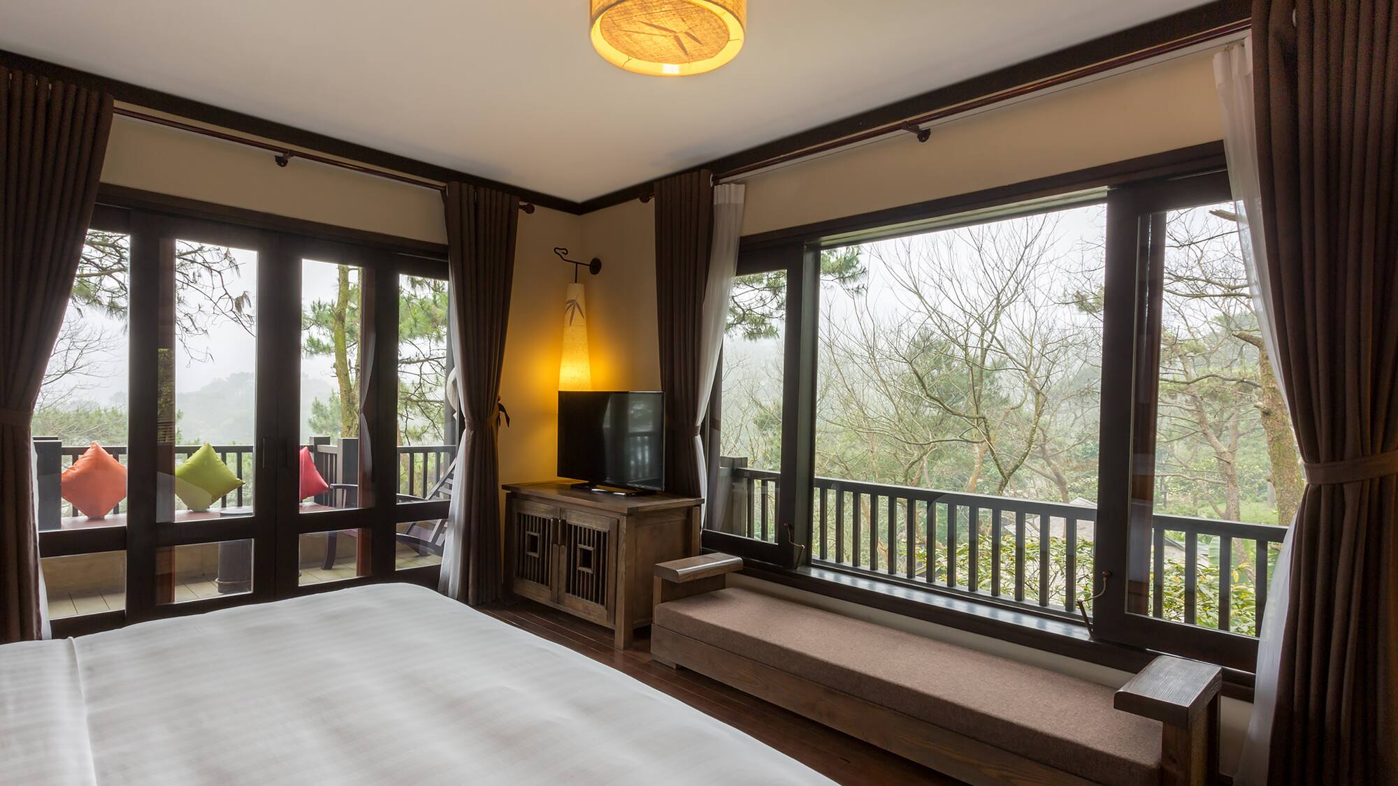 a bedroom with a bed and a bench and a window