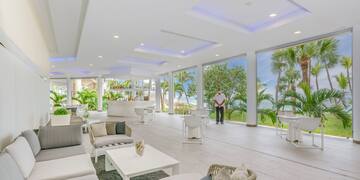 a man standing in a room with white furniture and tables