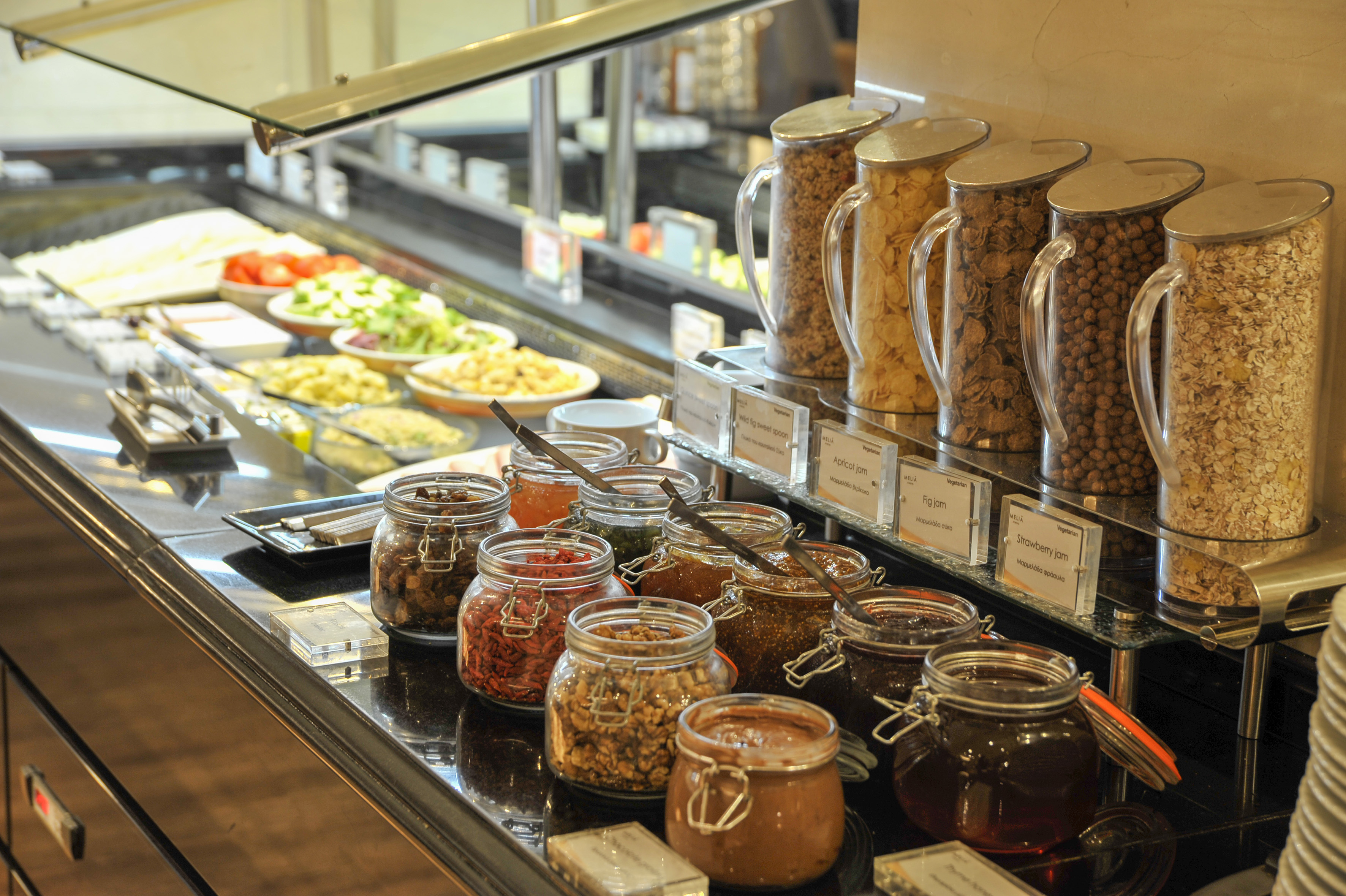 Hotel breakfast buffet with assorted jams, nuts, dried fruits, and cereals.