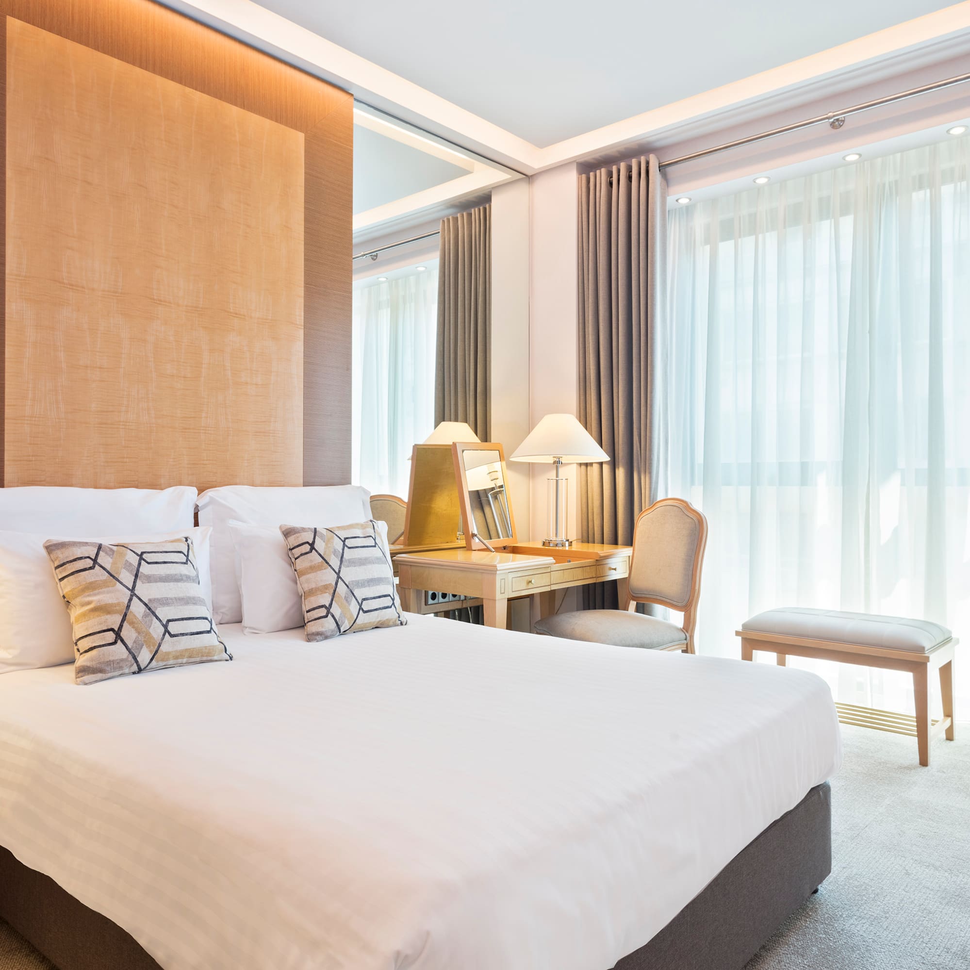 a bed with pillows and a desk in a room