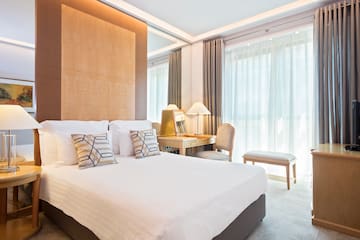 a bed with pillows and a desk in a room