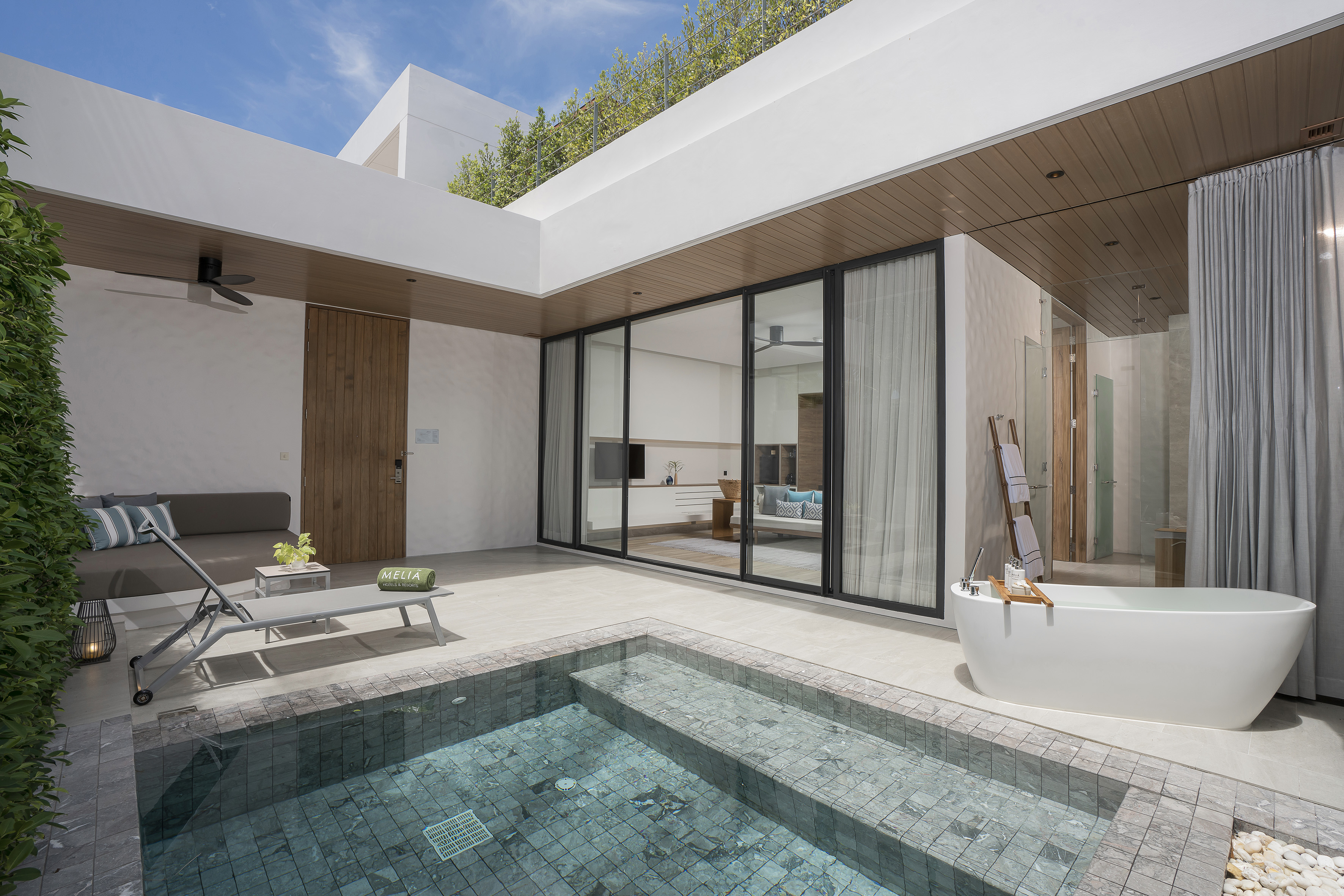 Private villa patio with plunge pool, outdoor bathtub, and lounge area.