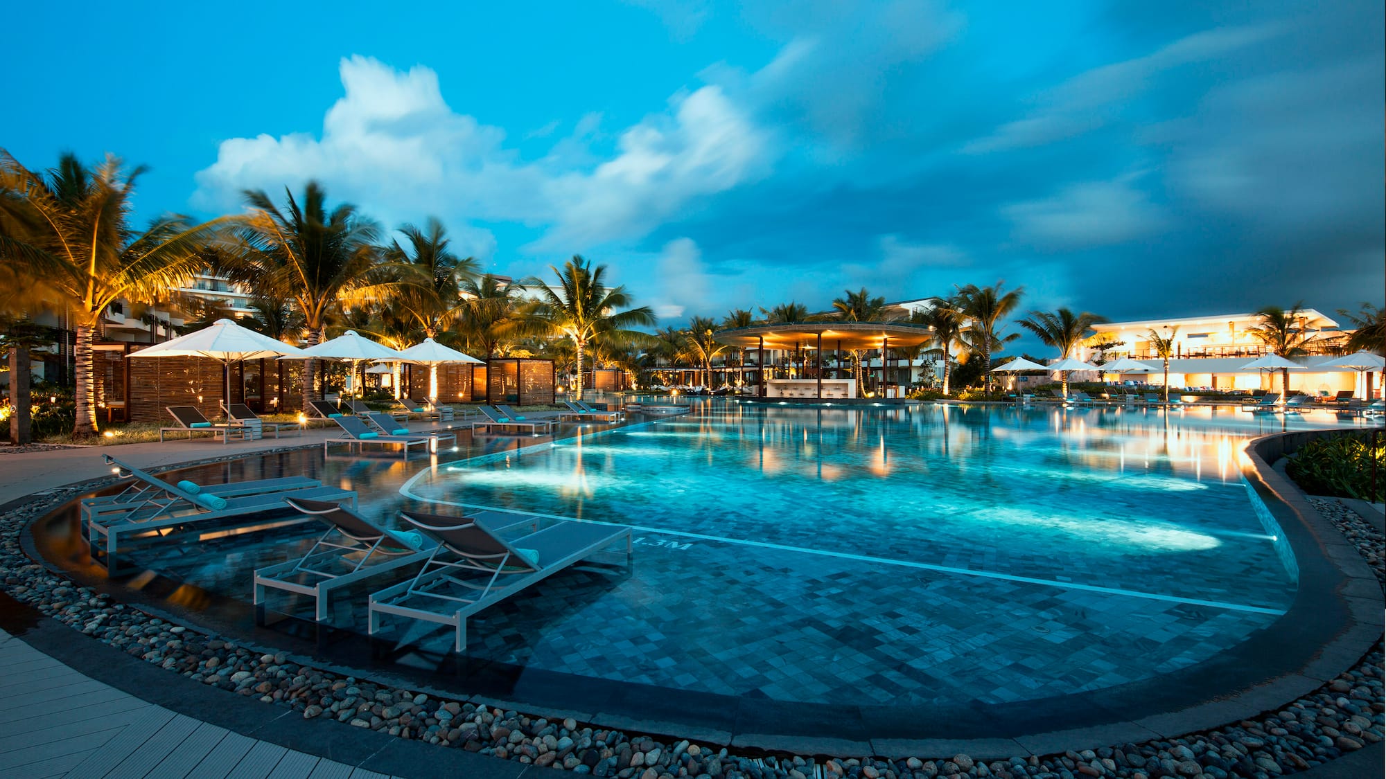 a pool with lounge chairs and a building in the background
