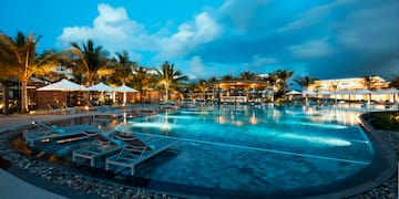 a pool with lounge chairs and a building in the background