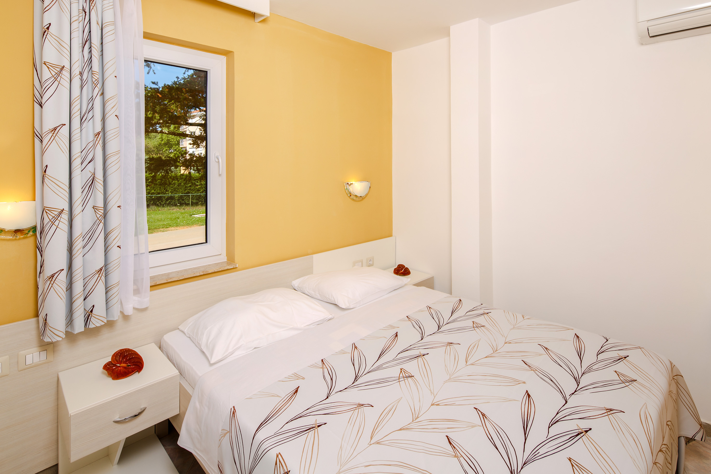 a bed with pillows and a window