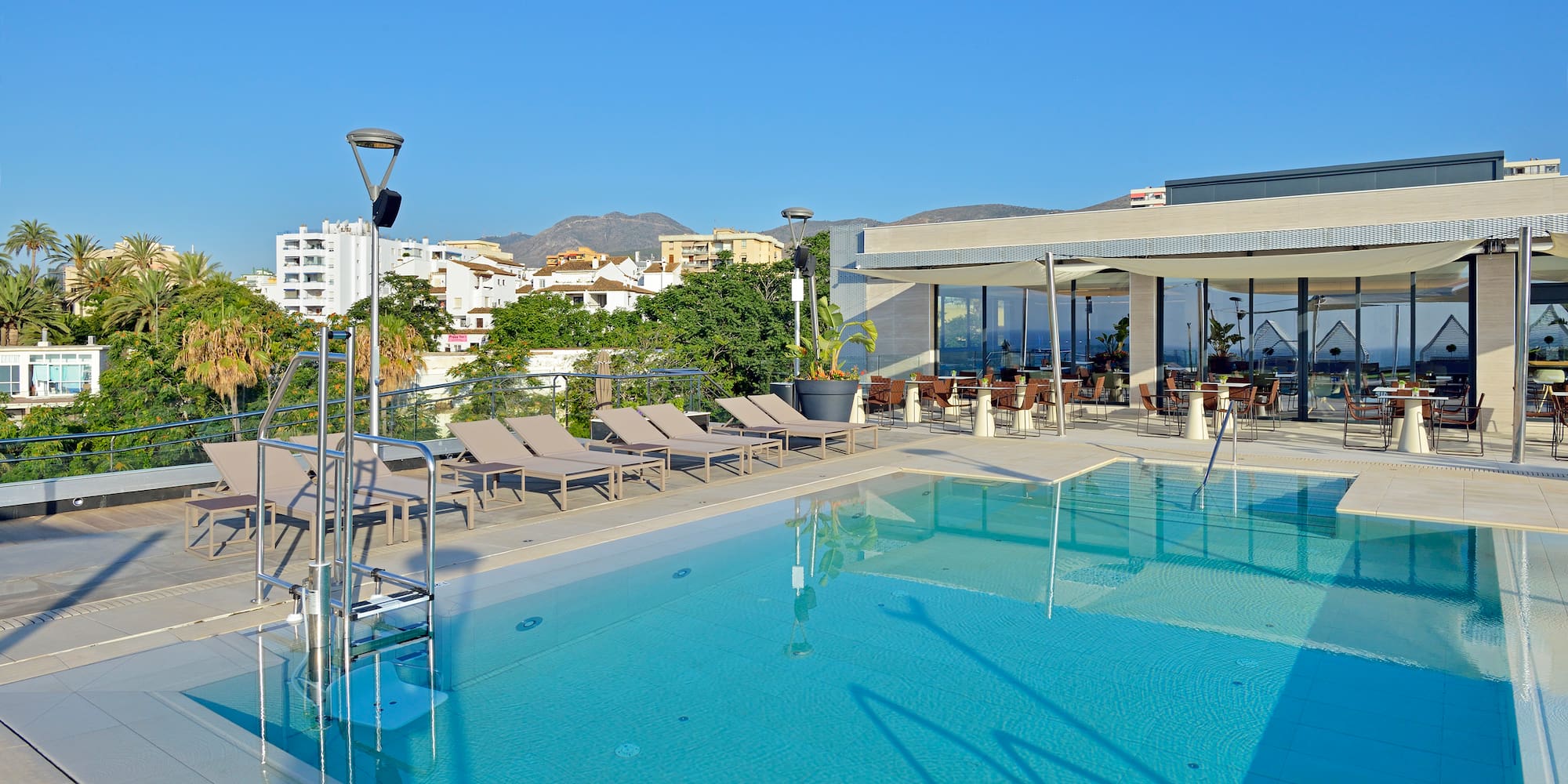 a swimming pool with chairs and a roof