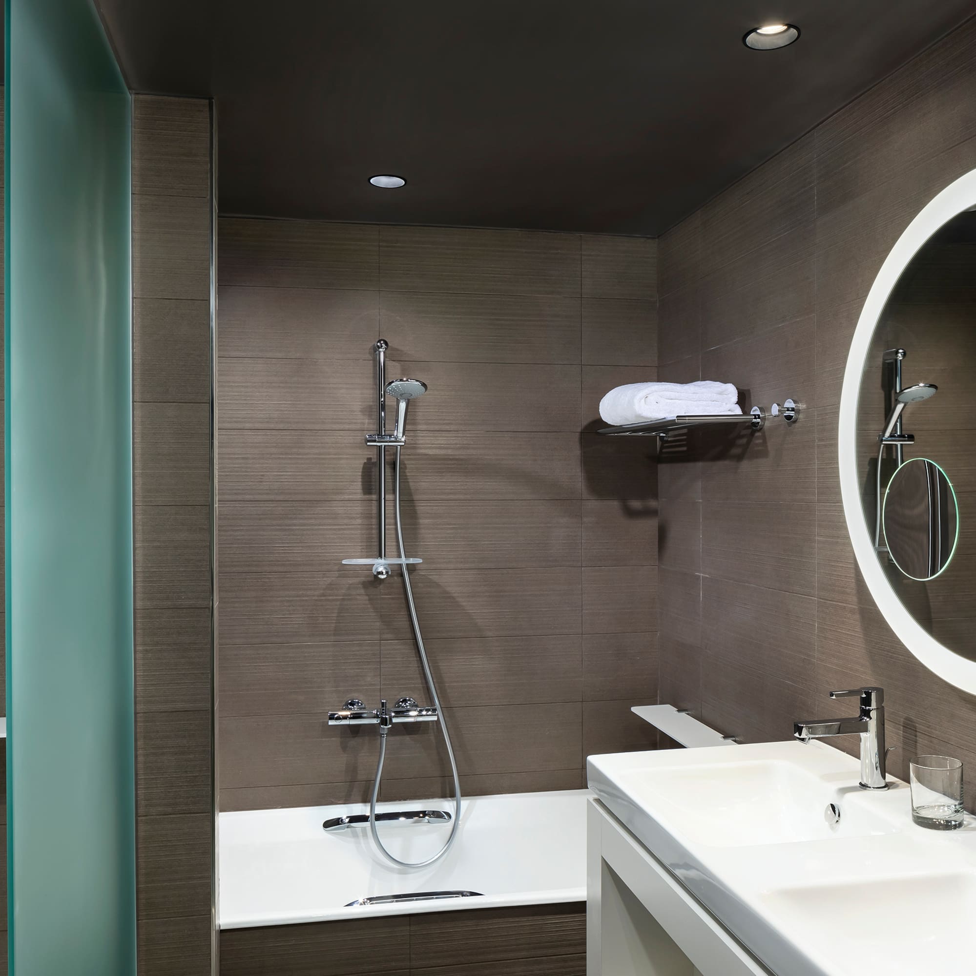 a bathroom with a round mirror and a bathtub