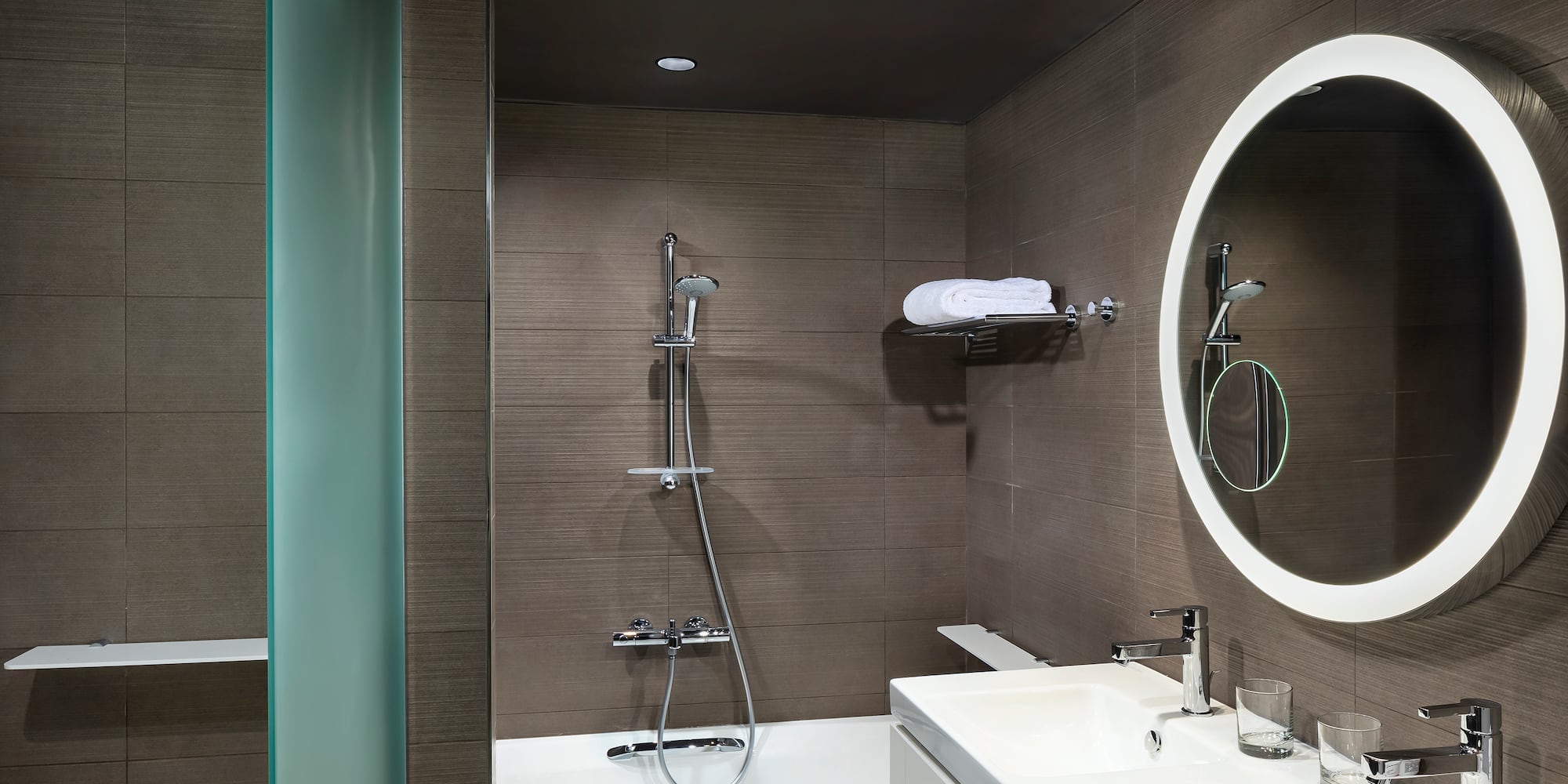 a bathroom with a round mirror and a bathtub