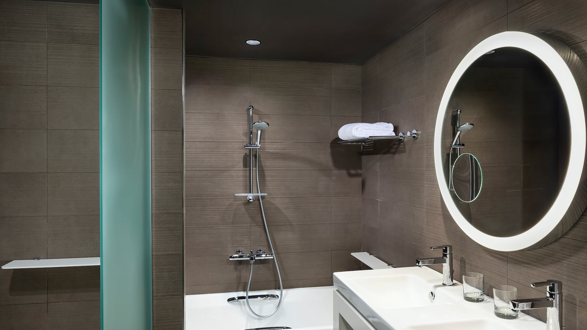 a bathroom with a round mirror and a bathtub
