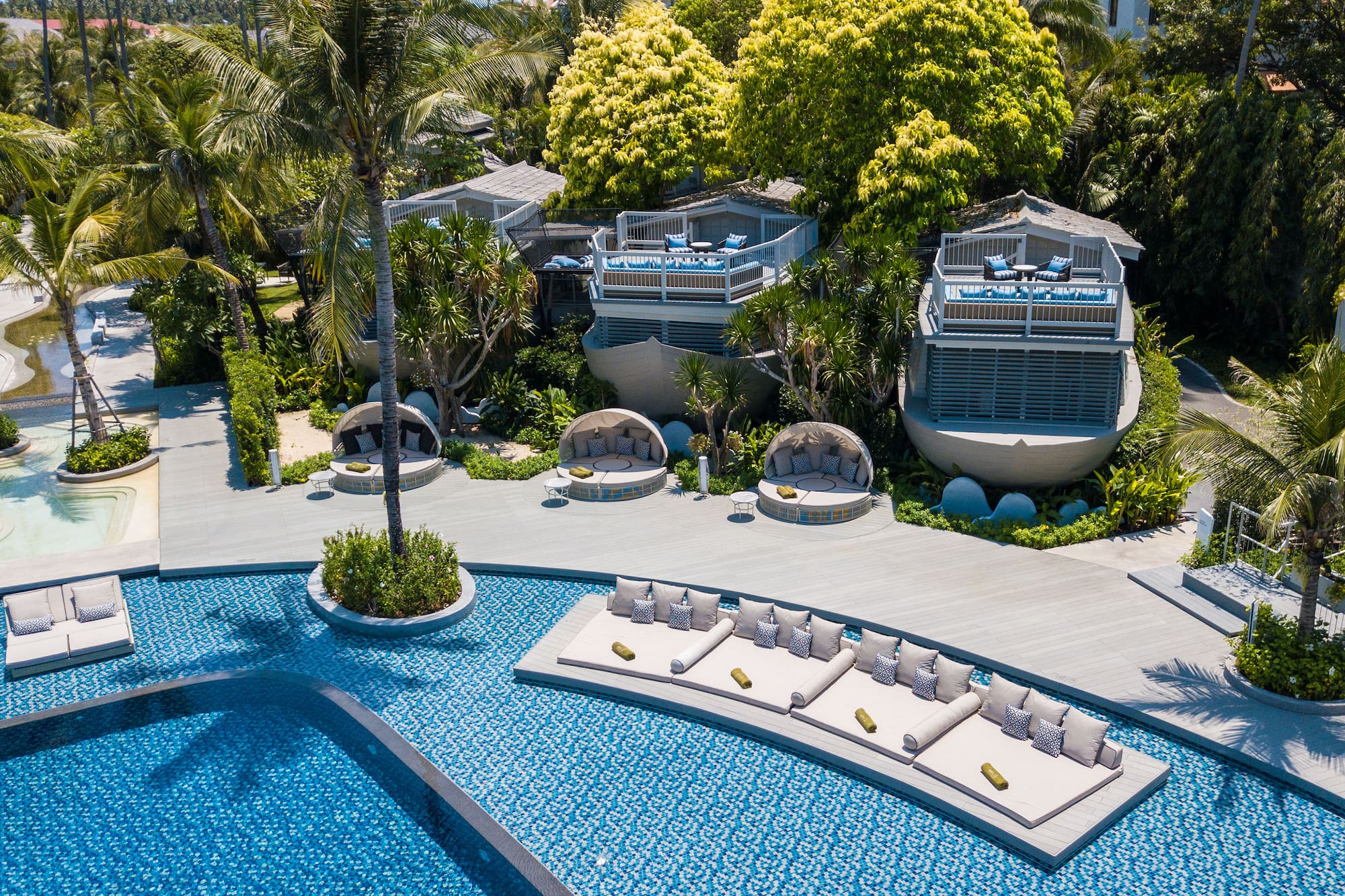 a pool with lounge chairs and trees