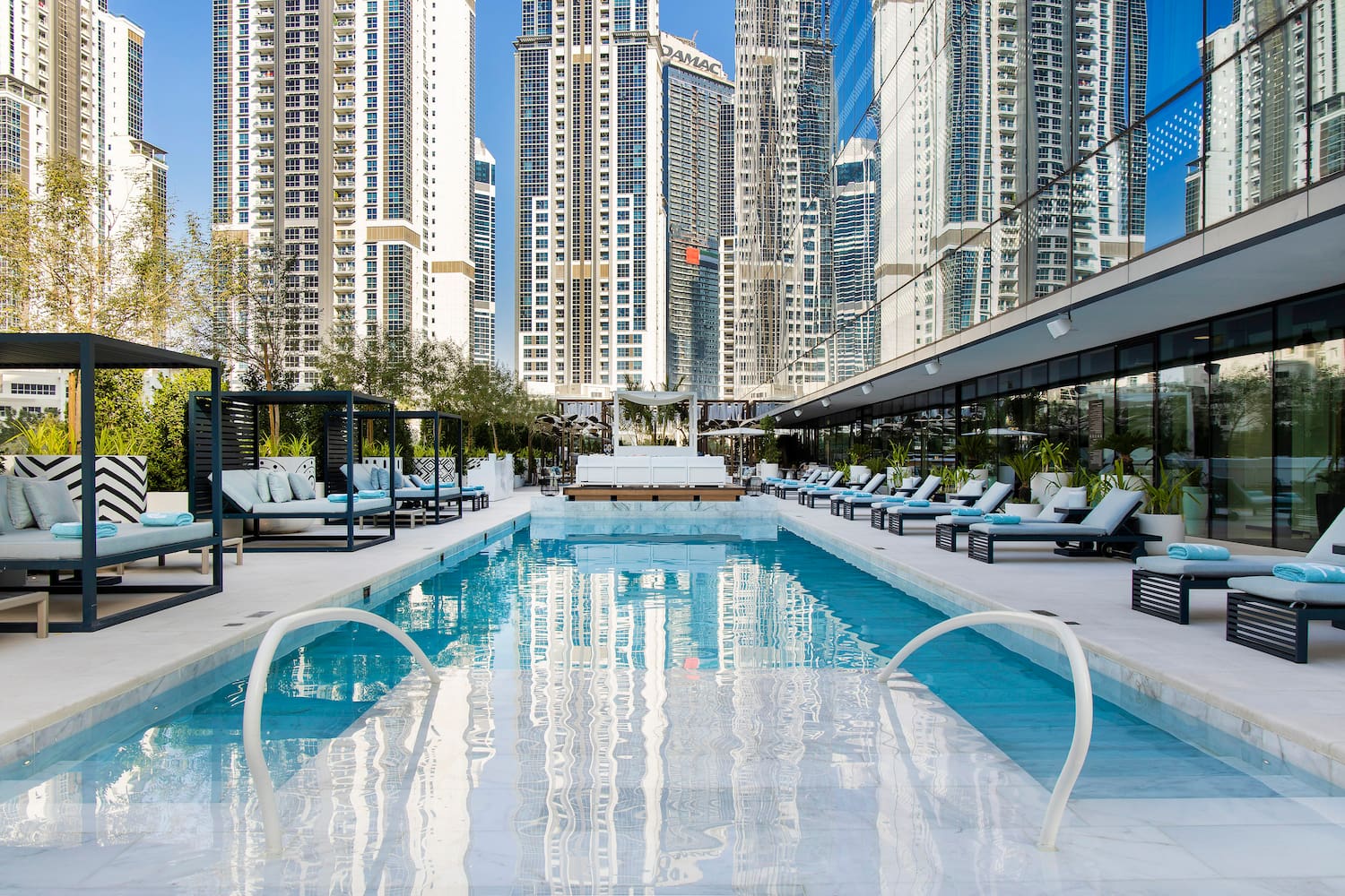 a pool with lounge chairs and a building in the background