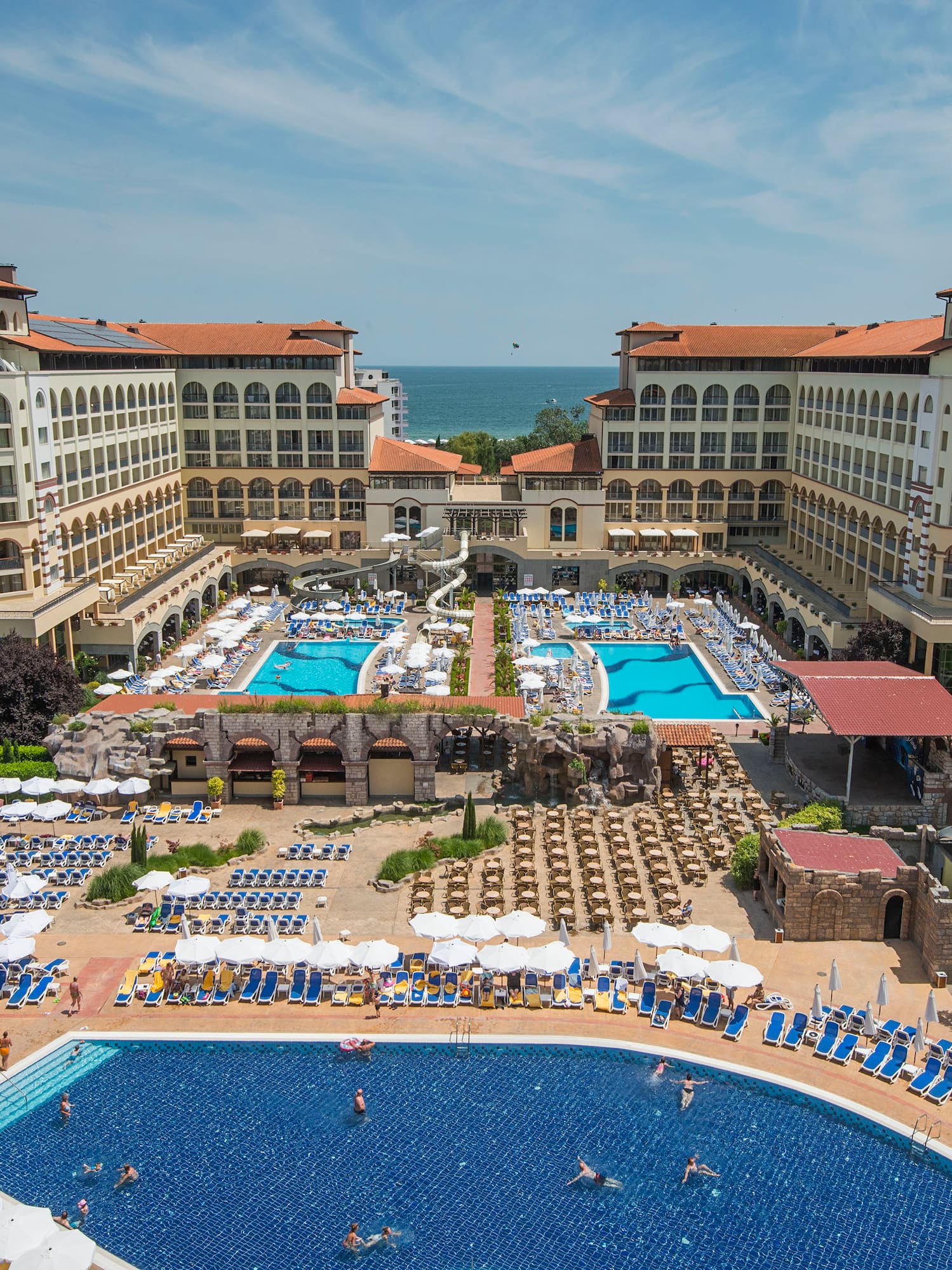 a swimming pool and a large building with many people